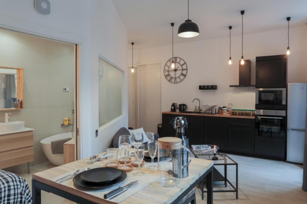 una cocina con una mesa con copas de vino. en Suite Garibaldi Cosy et Design en Lyon