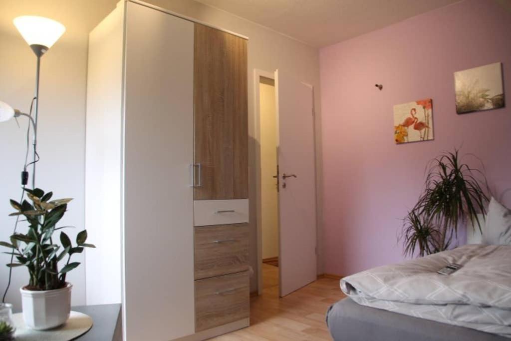 - une chambre avec un lit, une commode et un miroir dans l'établissement Ferienwohnung "An der Geest 2", à Buxtehude