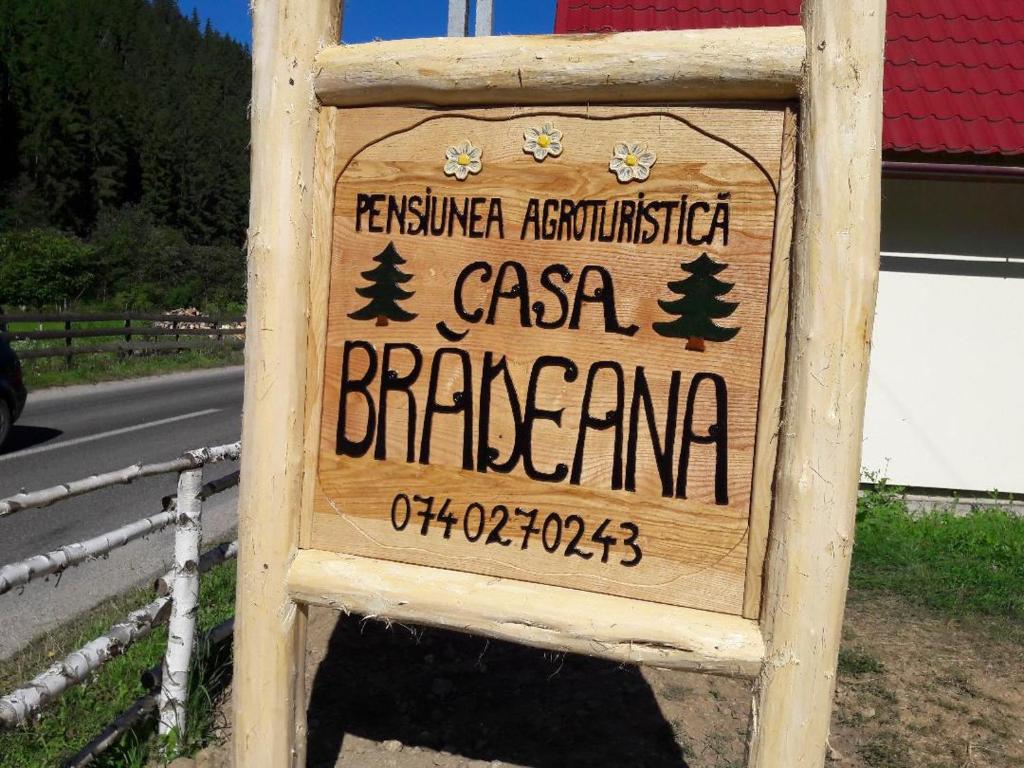 una señal para un restaurante al lado de una carretera en Pensiunea agroturistică Casa Brădeana, en Albac