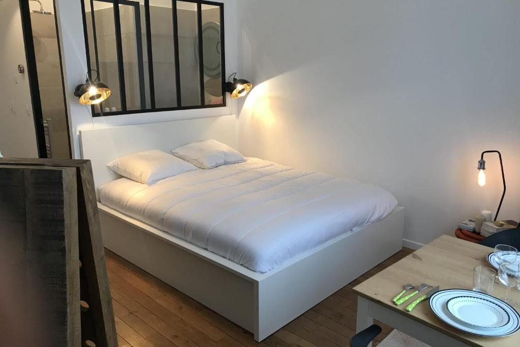 リヨンにあるLe Joyau de Jouhaux appartement G - Lyon Garibaldiの小さなベッドルーム(ベッド1台、テーブル付)