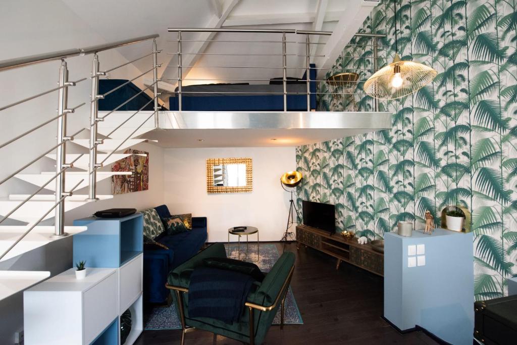 a living room with a blue couch and a staircase at Maison triplex JJ - Ecrin verdoyant au coeur de Lyon in Lyon