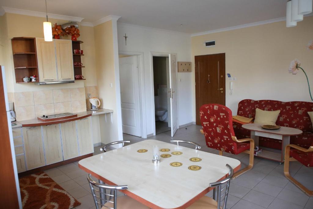 kuchnia i salon ze stołem i krzesłami w obiekcie Apartament Bałtycka Plaża w Ustce
