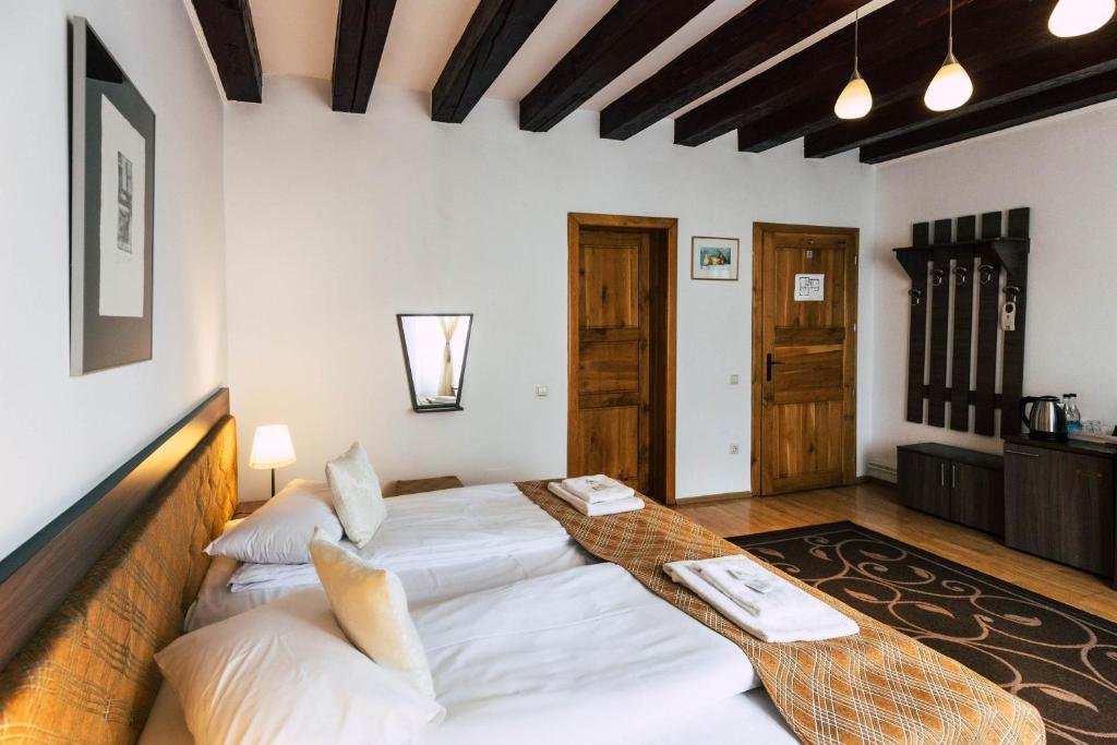 a bedroom with a large white bed in a room at Pension Gallery in Braşov
