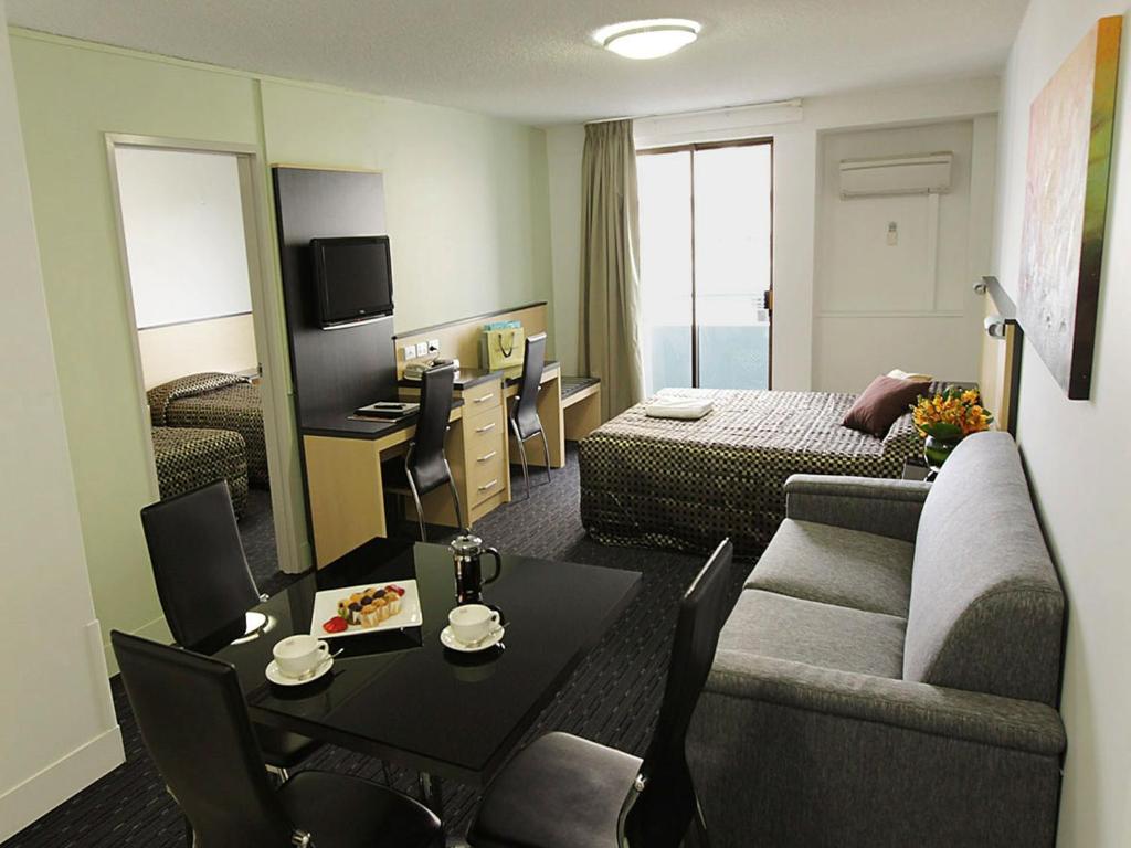 un soggiorno con divano e tavolo in una camera d'albergo di Comfort Inn & Suites Goodearth Perth a Perth