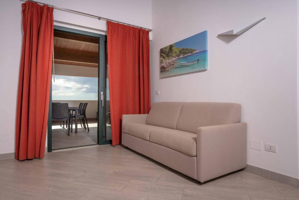 a living room with a couch and a sliding glass door at La Rotonda Trilocale vista mare in Albinia