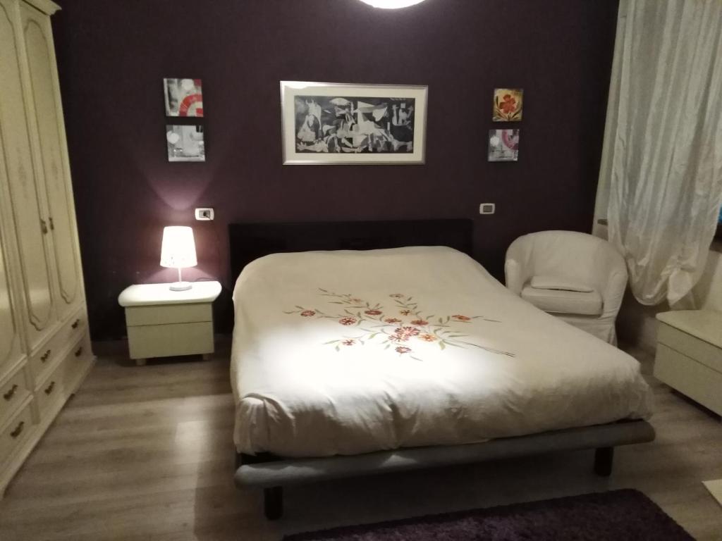 una camera con letto, sedia e lampada di Garibaldi n°12 a Volterra