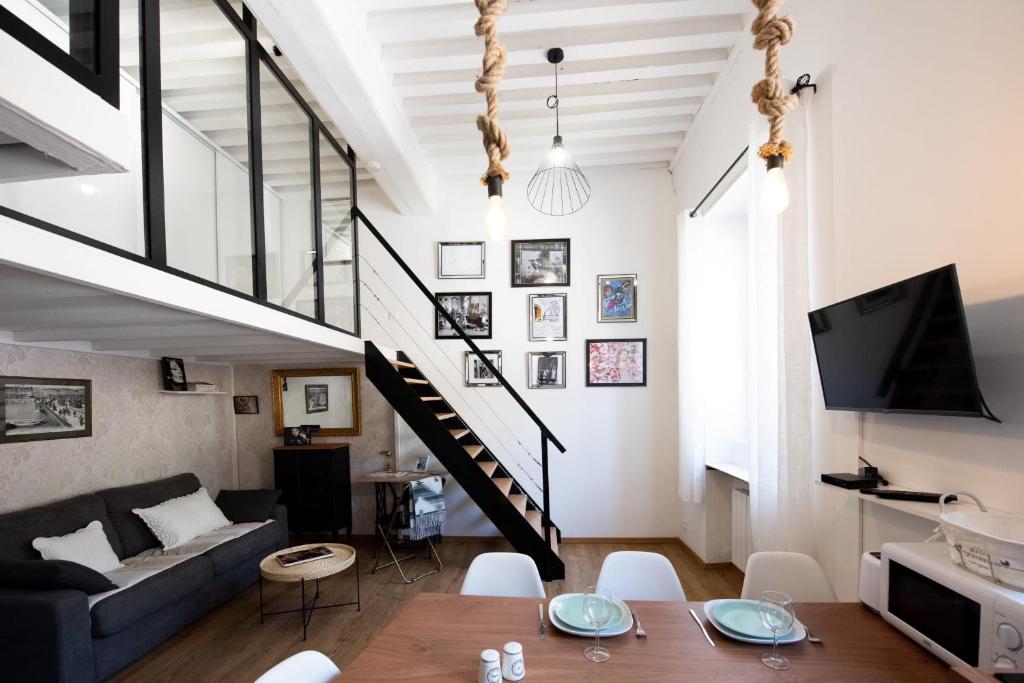- un salon avec un canapé et un escalier dans l'établissement Le Ferratière - Moderne industriel du Vieux Lyon, à Lyon