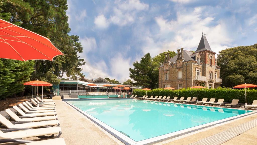 波爾尼謝的住宿－雷斯當斯酒店，一座带椅子和遮阳伞的游泳池以及一座建筑