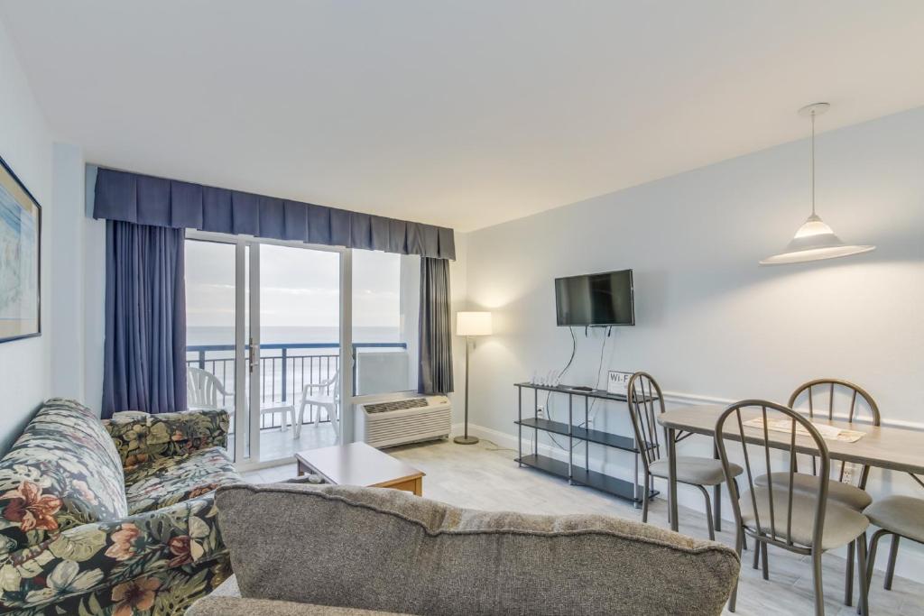 マートルビーチにあるHosteeva Oceanfront Boardwalk Beach Resort with Balconyのソファとテーブルのあるリビングルーム