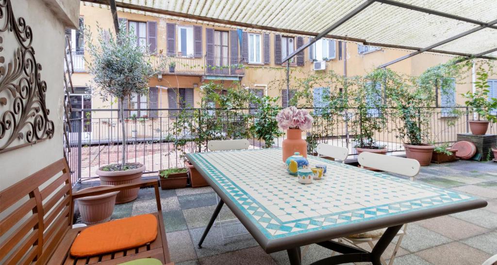 d'une terrasse avec une table et des chaises sur un balcon. dans l'établissement ALTIDO Apt for 6 with Big Terrace in Milan Centro Storico, à Milan