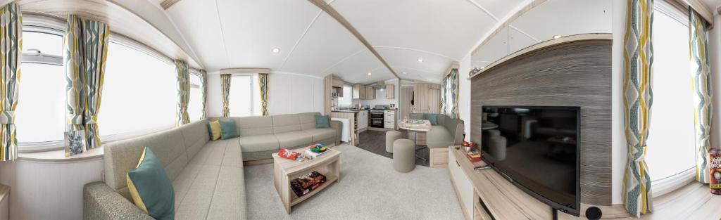 a living room with a couch and a television at Roselands caravan park, Nr Lands End, Cornwall in St. Just