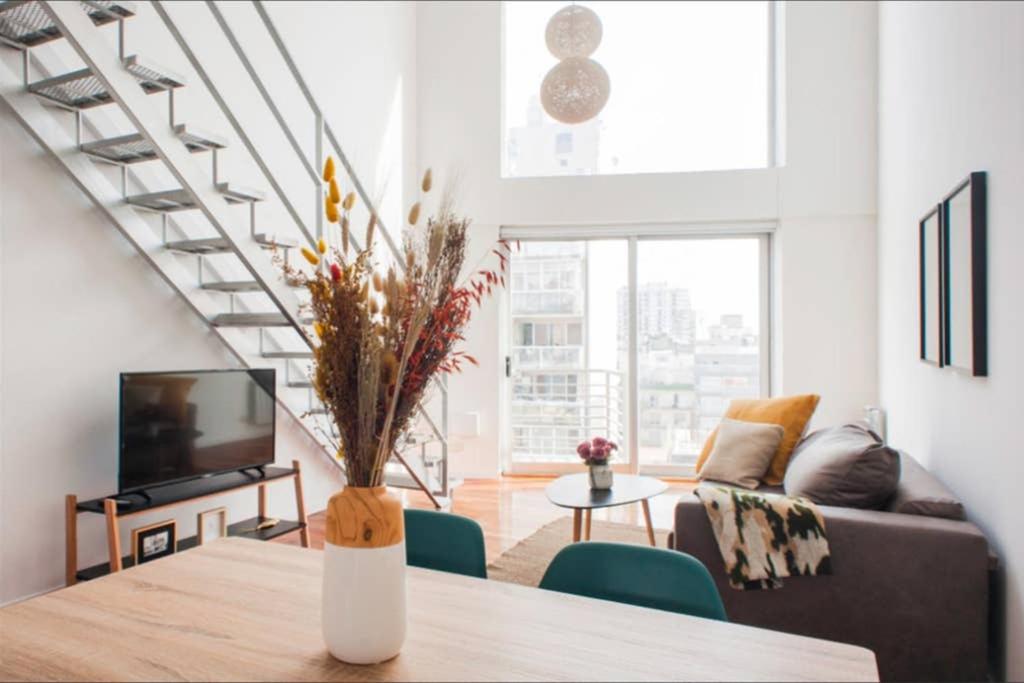 uma sala de estar com um vaso de flores sobre uma mesa em Luminosos Loft En Recoleta 2 Cuadras Del Subte em Buenos Aires