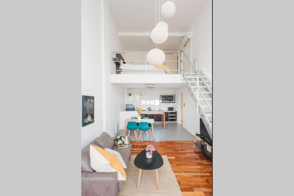 un soggiorno con un divano e una scala di Luminosos Loft En Recoleta 2 Cuadras Del Subte a Buenos Aires