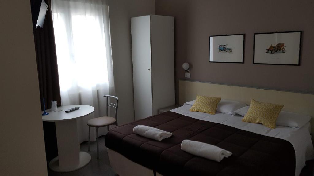 um quarto com uma cama, uma mesa e uma janela em Hotel Arianna em Iseo