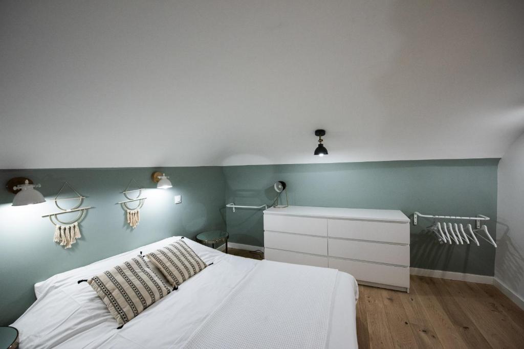 ein Schlafzimmer mit einem weißen Bett und grünen Wänden in der Unterkunft Le duplex d'André - Un écrin cosy et design pour 2 in Lyon