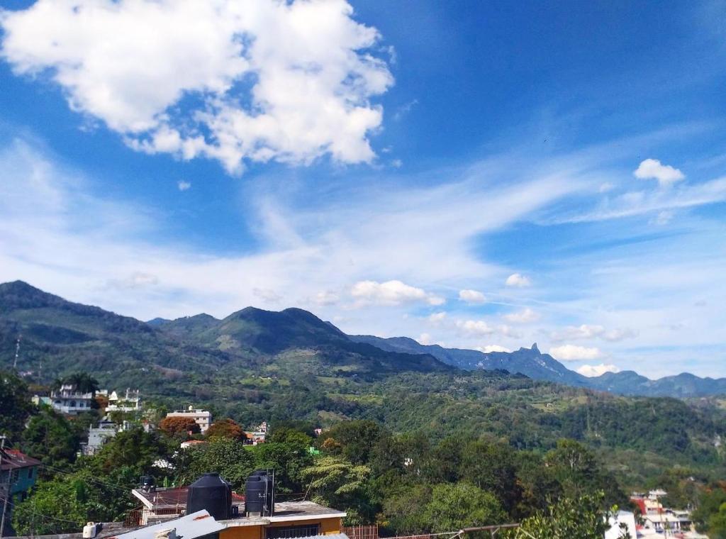 - une vue sur une ville avec des montagnes en arrière-plan dans l'établissement Sukha Hostel Xilitla, à Xilitla