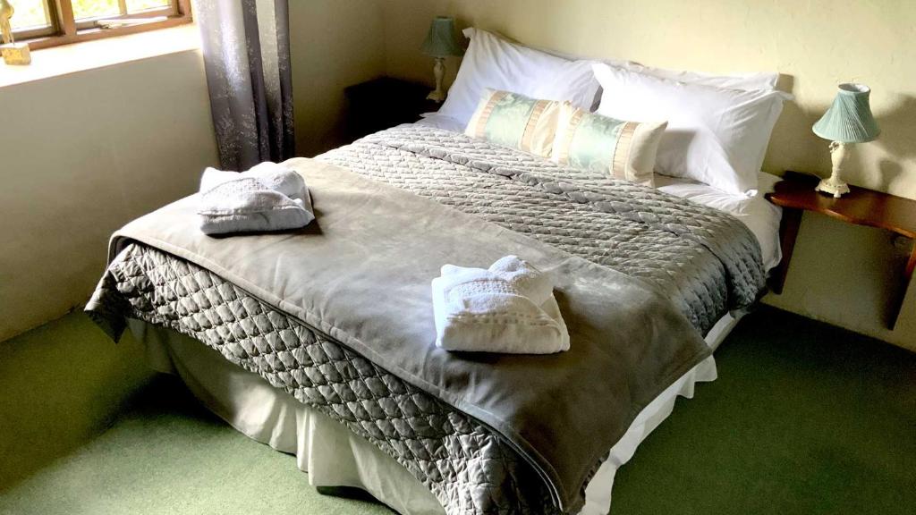 a bedroom with a large bed with towels on it at Mill House - Devon Holiday Accommodation in Sidmouth