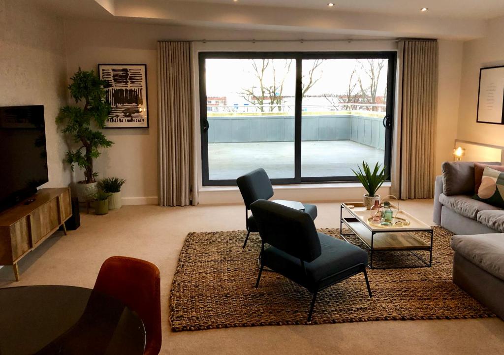 a living room with a couch and a table and a tv at Chapel Penthouse in York