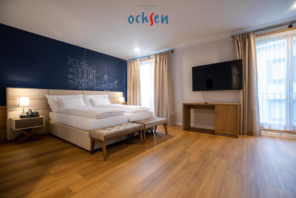 a bedroom with a large bed and a tv at Boutique Hotel OchSen Self-Check-In in Bad Ragaz