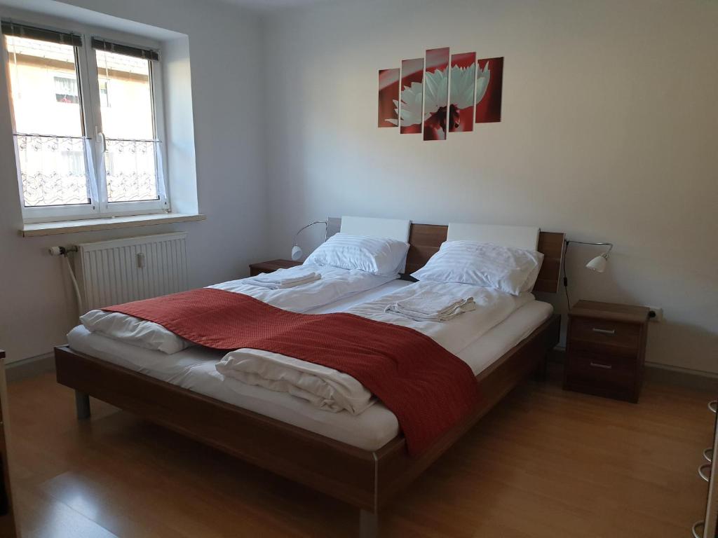 a large bed in a bedroom with two windows at Four Seasons Apartment Josef in Eisenerz