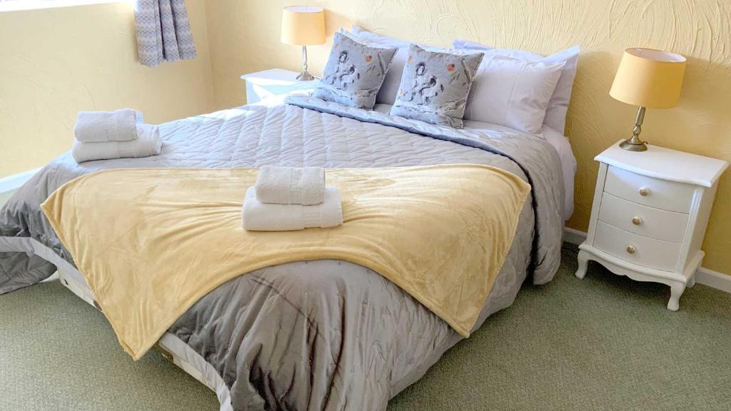 a bedroom with a large bed with towels on it at Cider Cottage - 3 Bedroom - Onsite Parking in Sidmouth