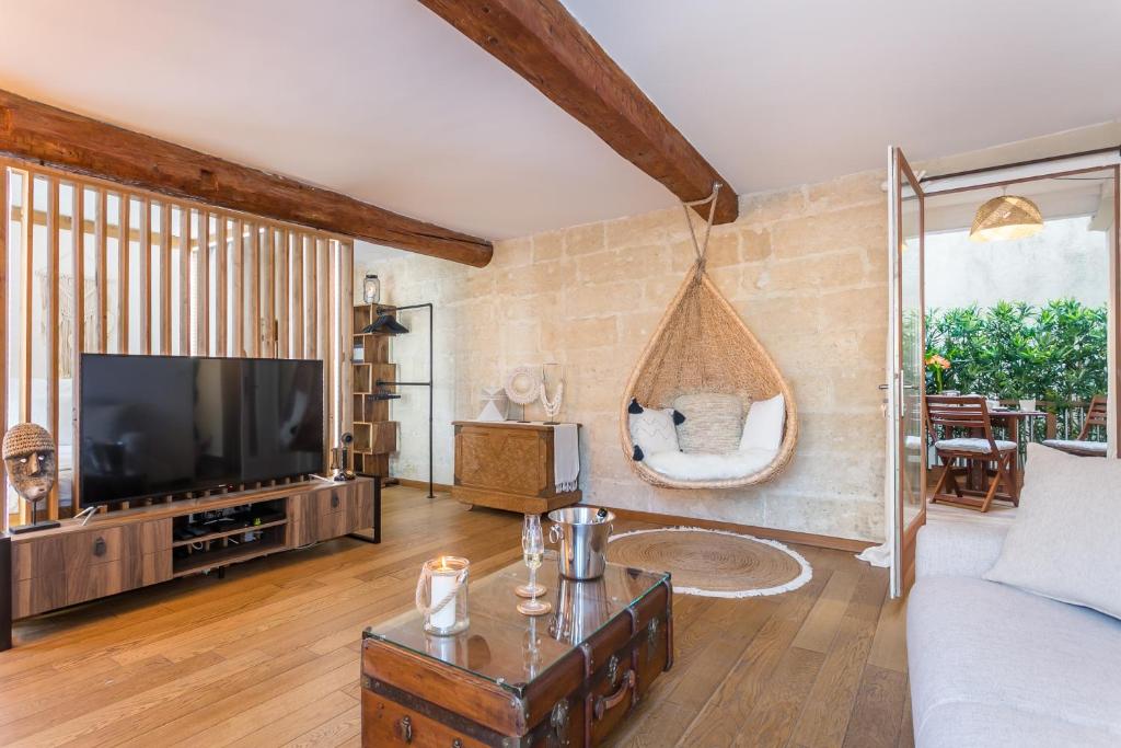 een woonkamer met een bank en een tv bij My Pad Provence 6 in Avignon