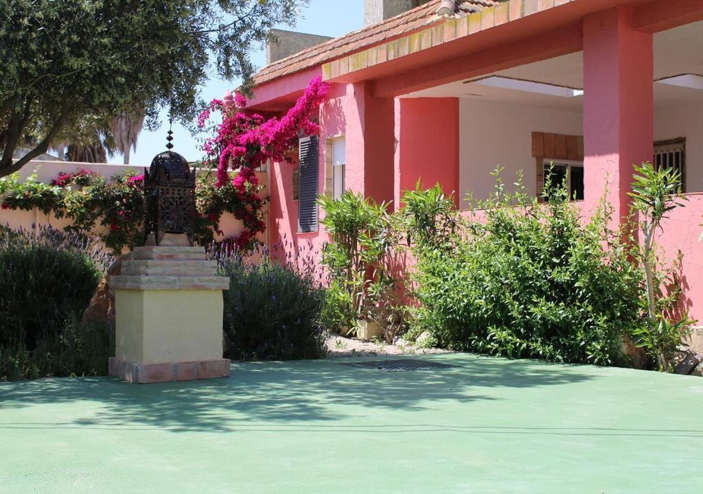 una casa rosa con una estatua delante de ella en Finca Doña Sofia Mª, adaptada para personas con movilidad reducida, en San Pedro del Pinatar