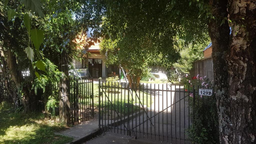 a gate in front of a house with trees at Mar-al Apartments in Valdivia