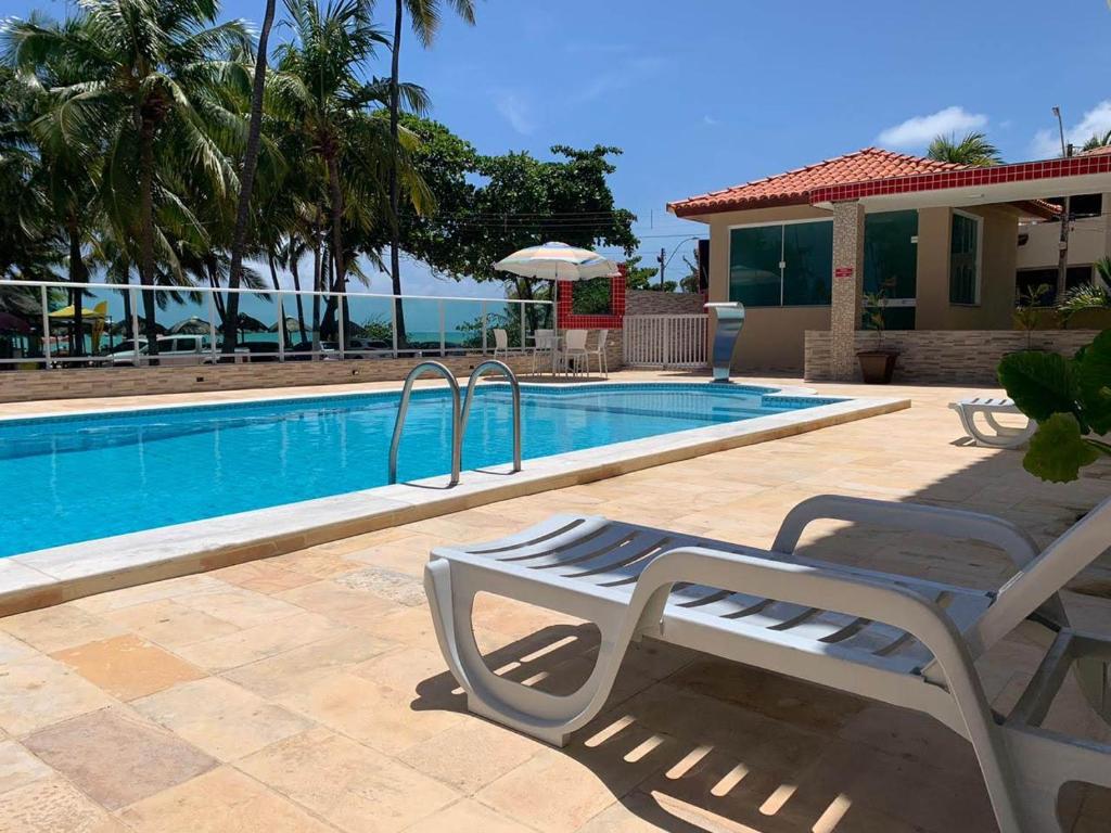a swimming pool with two lounge chairs next to it at Summit Pousada Noah in Maceió