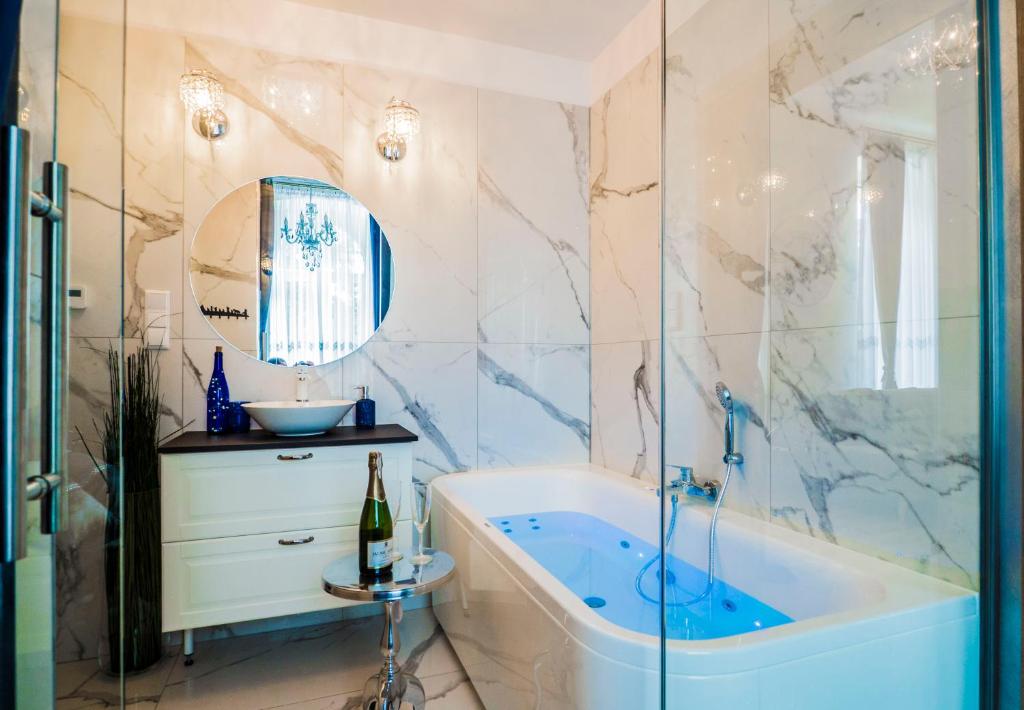a bathroom with a tub and a sink at El Dorado Apartment z Jacuzzi in Wrocław