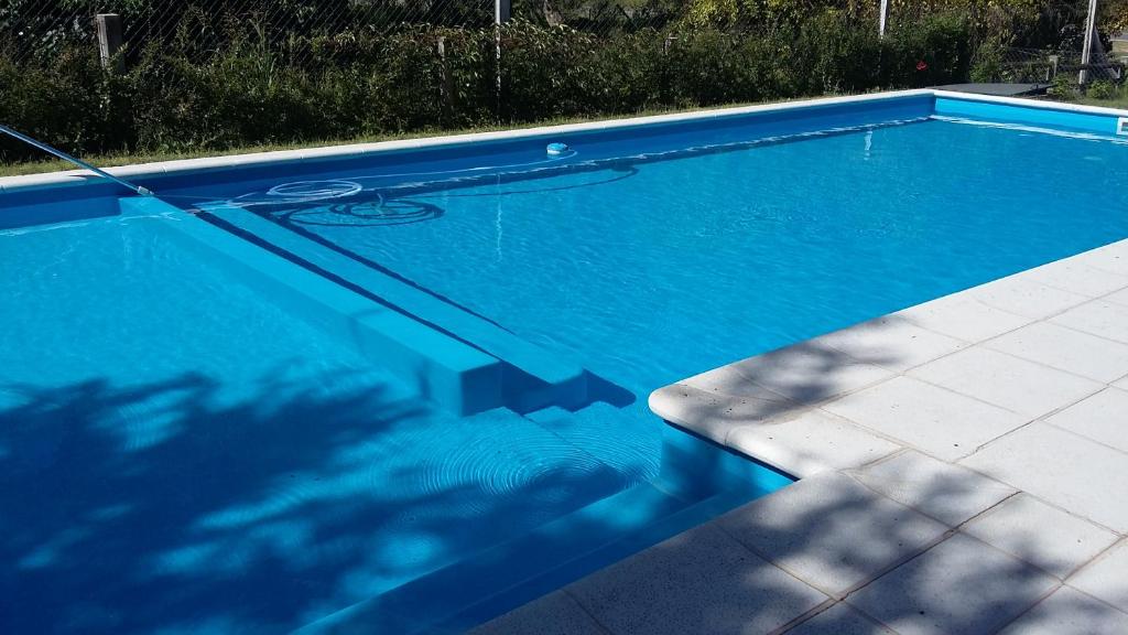 basen z błękitną wodą na dziedzińcu w obiekcie Cabañas Alma Comechingon w mieście Villa Cura Brochero