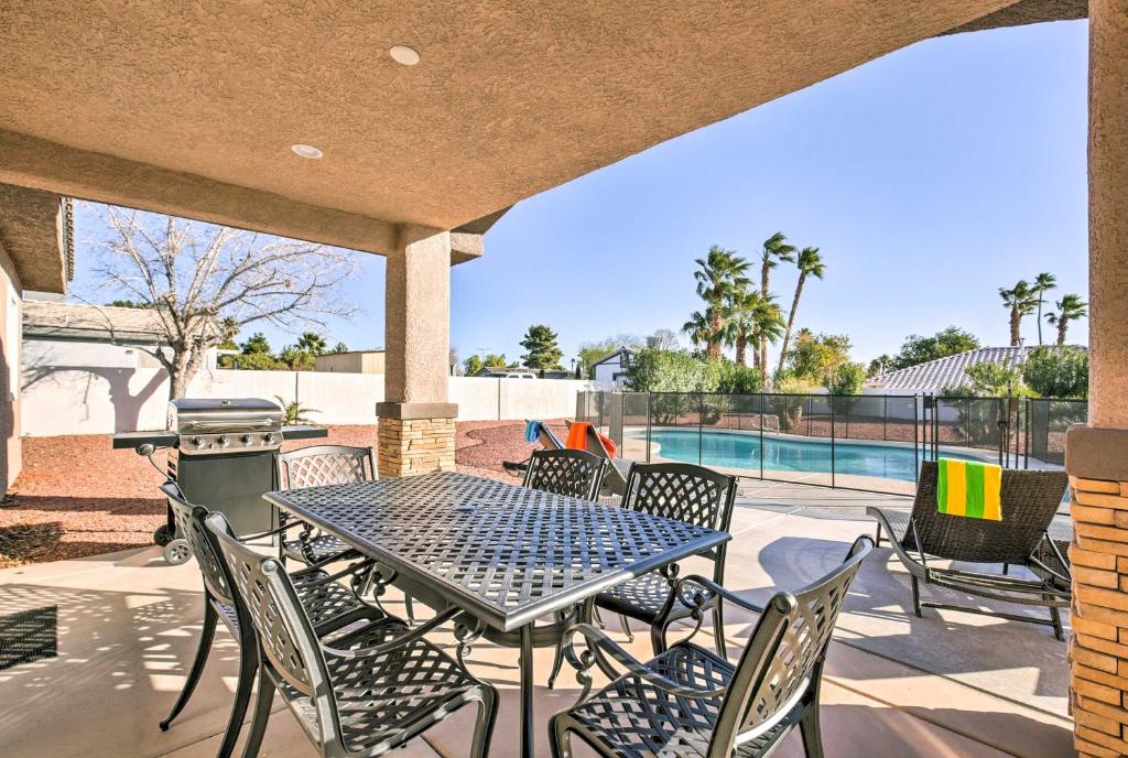 um pátio com uma mesa e cadeiras e uma piscina em Updated Las Vegas House with Patio, Solar Heated Pool em Las Vegas