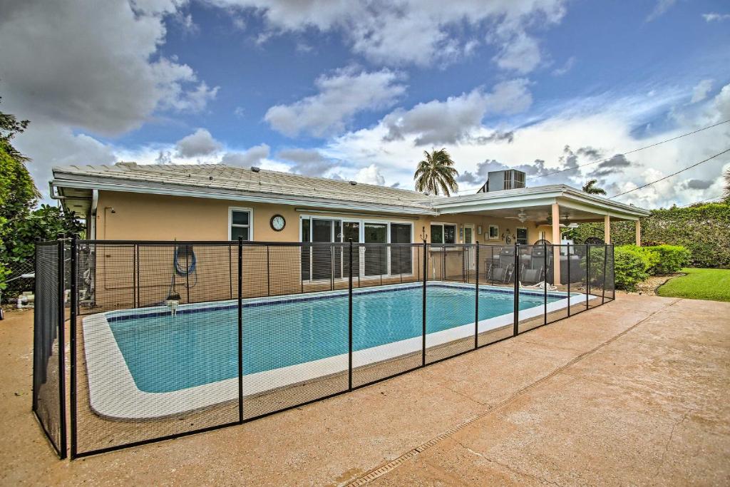 a house with a swimming pool in front of a house at Riviera Beach Vacation Home with Pool Walk to Beach in Riviera Beach