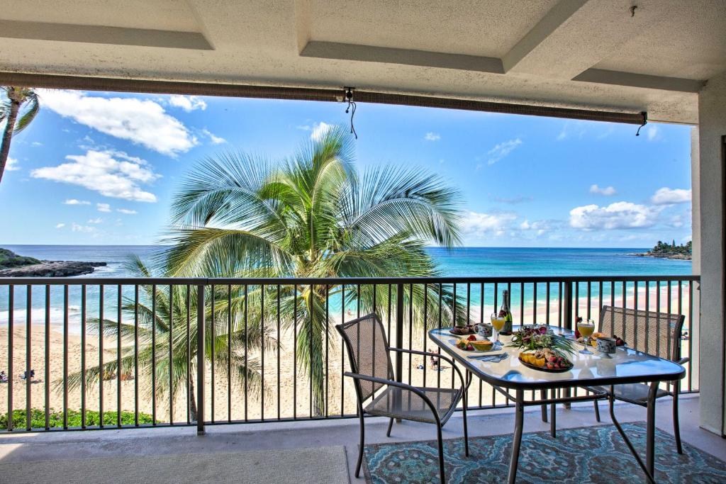 a table on a balcony with a view of the beach at Stunning Makaha Condo with Pool Access and Ocean View! in Waianae