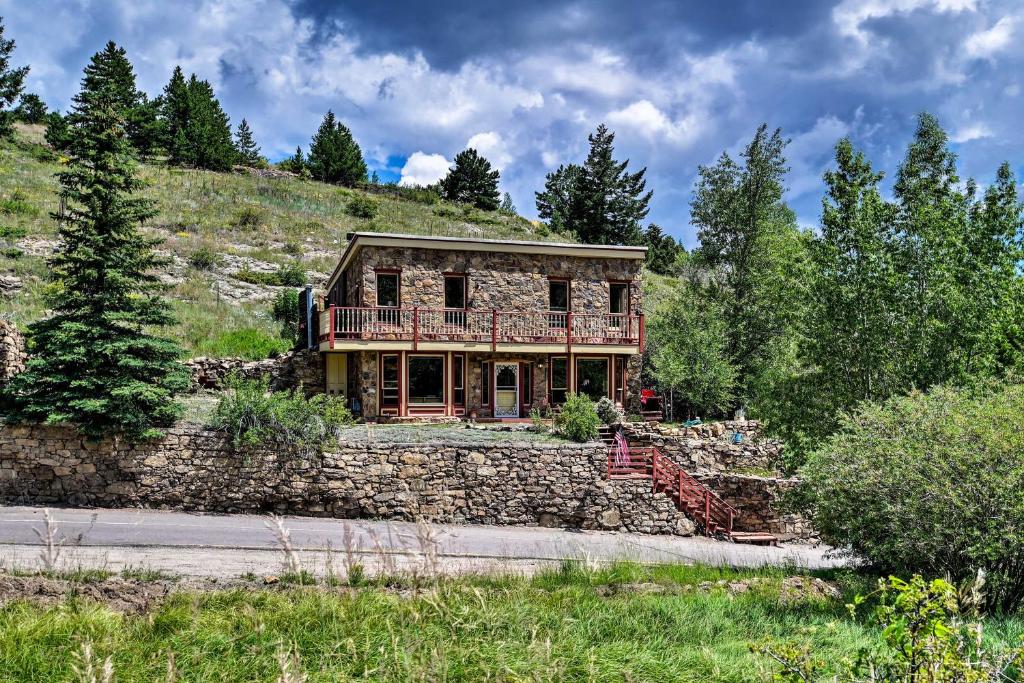 a house on a hill with a stone wall at Cozy Home with Deck and Mountain Views, Walk to Casinos in Central City