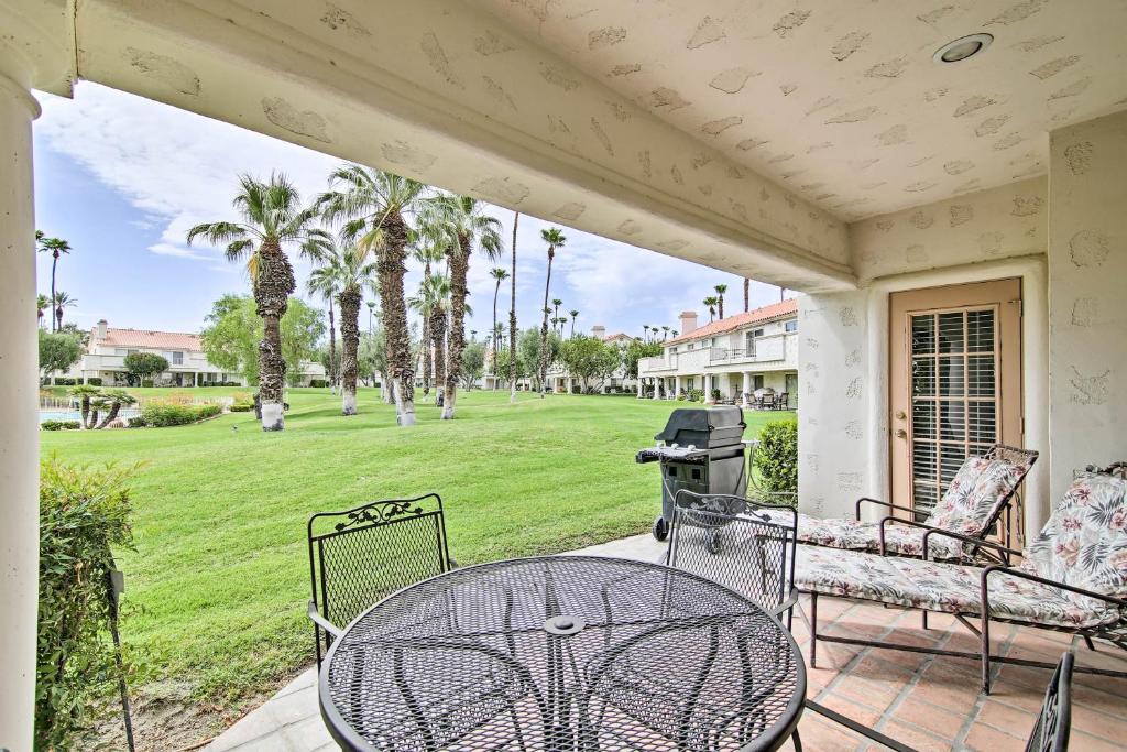 a patio with a table and chairs and a lawn at Palm Desert Country Club Home with Patio and Grill! in Palm Desert