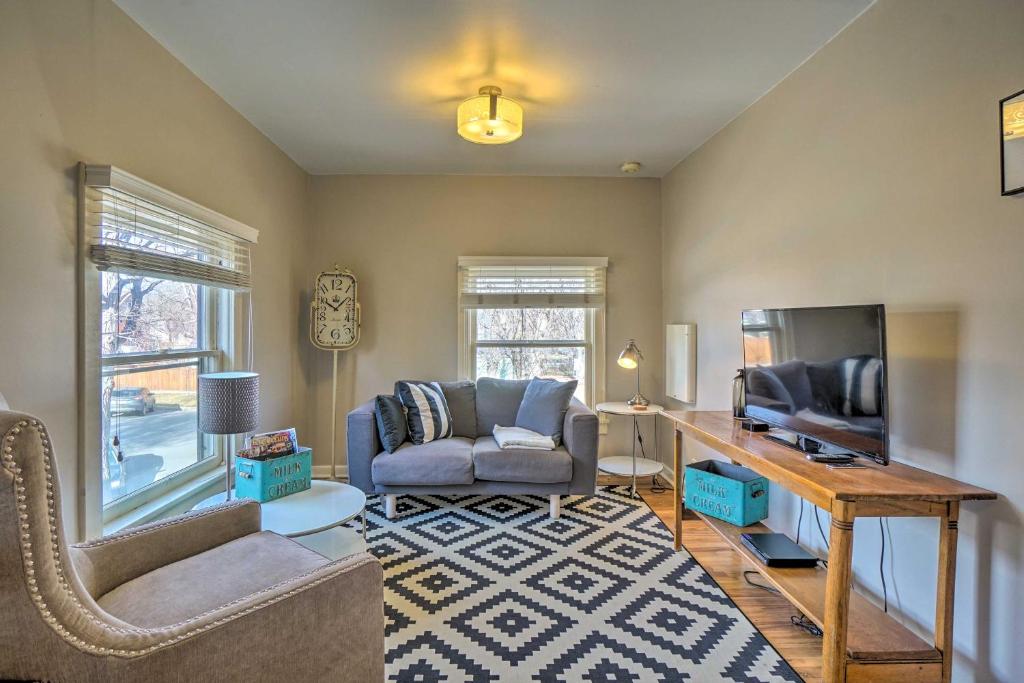a living room with a couch and a tv at Historic Apartment - Walk to CSU Campus and Old Town in Fort Collins