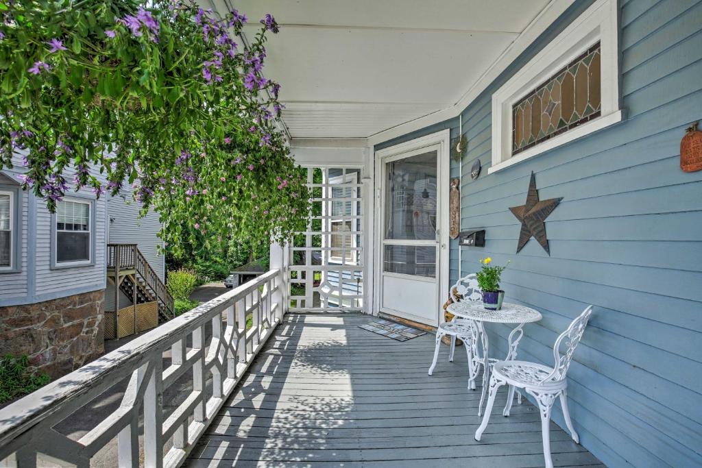 a porch with a table and chairs on a blue house at Quaint Beverly Townhome Walk to Beach and Downtown! in Beverly