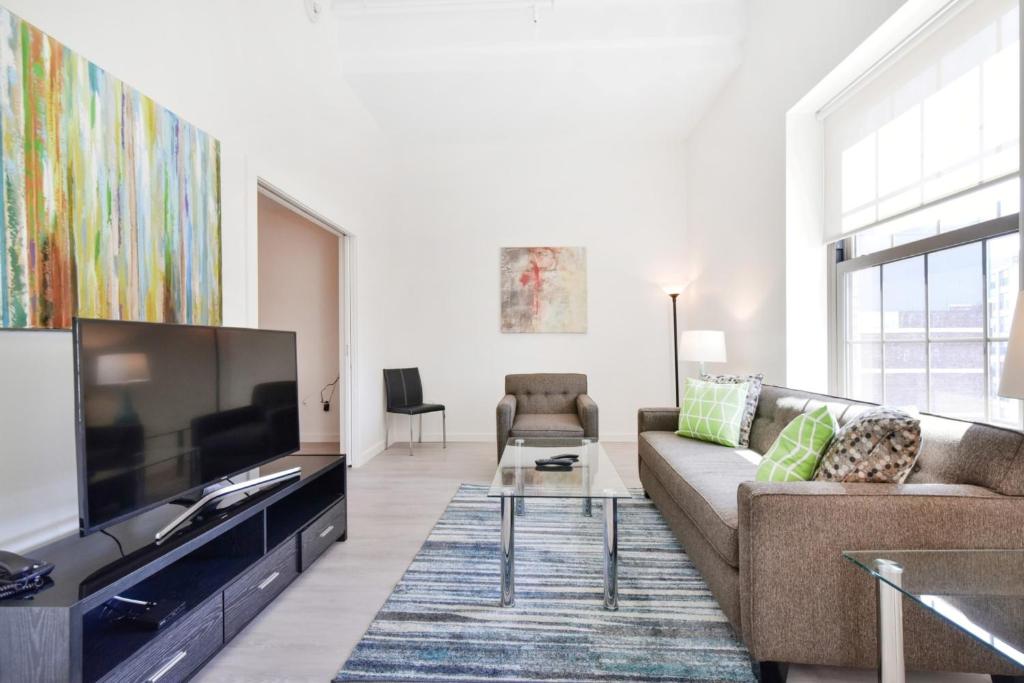 a living room with a couch and a large television at Harmony Medical Suites ChinaTown in Boston