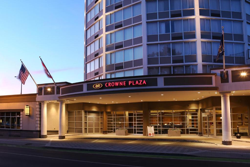 a rendering of the corner plaza building at night at Crowne Plaza Syracuse, an IHG Hotel in Syracuse