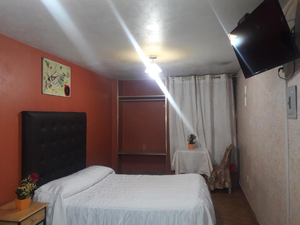 a bedroom with a bed and a television and a table at Los Apus Mayaki in Juliaca
