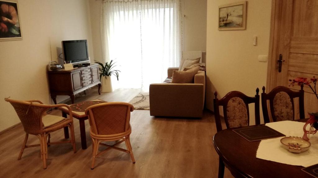 een woonkamer met een tafel en stoelen en een televisie bij u Eli, Bawarczyków 7-69 Toruń, PARKING FREE in Toruń