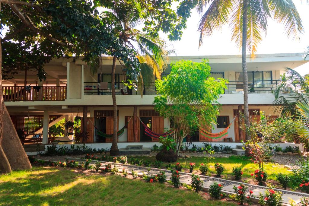 a building with a garden in front of it at Casa Chapolin Boutique Guesthouse in Palomino