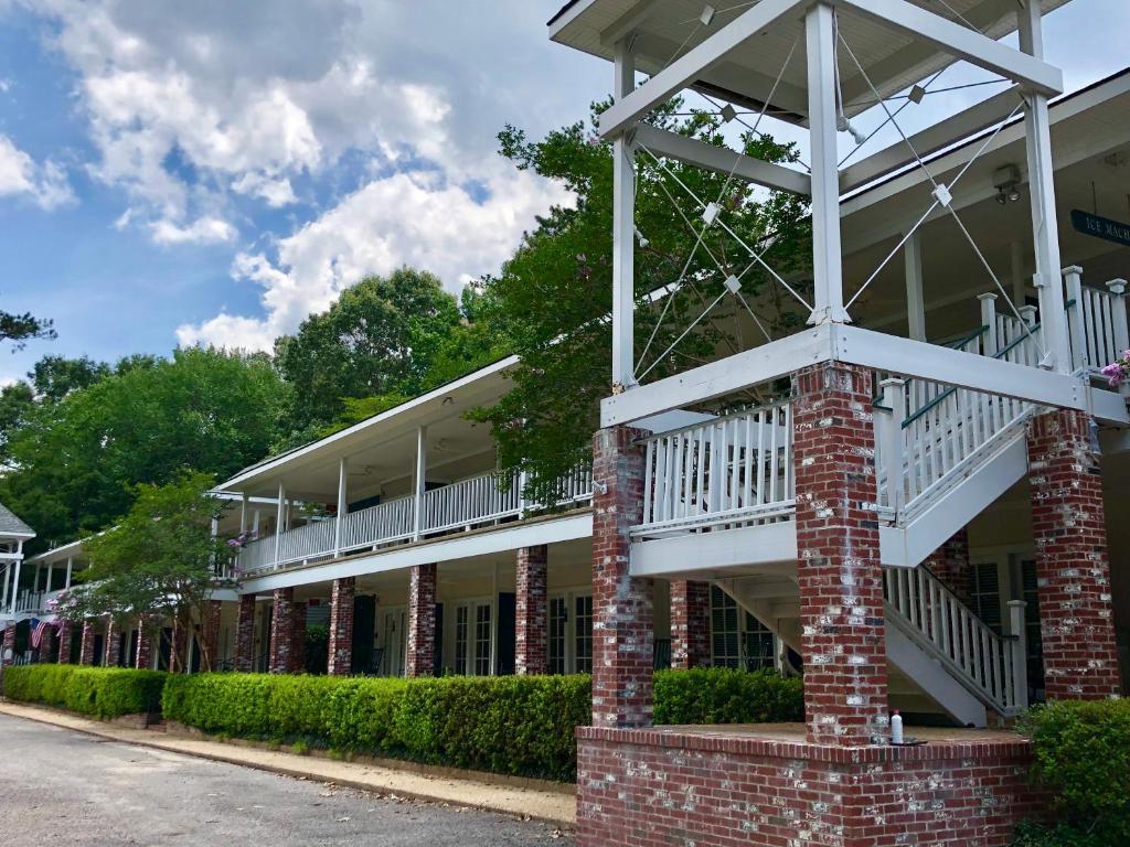 a brick building with white balconies on a street at The Lodge at The Bluffs in Saint Francisville