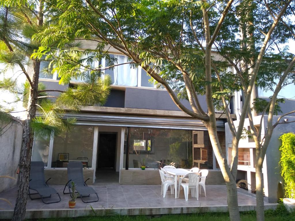 uma casa com um pátio com uma mesa e cadeiras em Amplia casa en Zona Parque San Carlos em Concordia