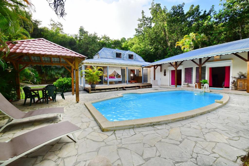 - une piscine avec une terrasse et une maison dans l'établissement GUADELOUPE MAISON PARADISE, au Gosier