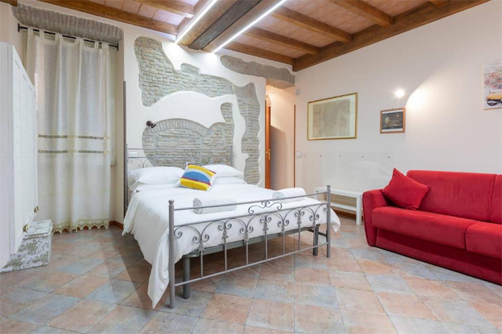 ローマにあるRione Di Roma Center Apartmentのベッドルーム1室(ベッド1台、赤いソファ付)