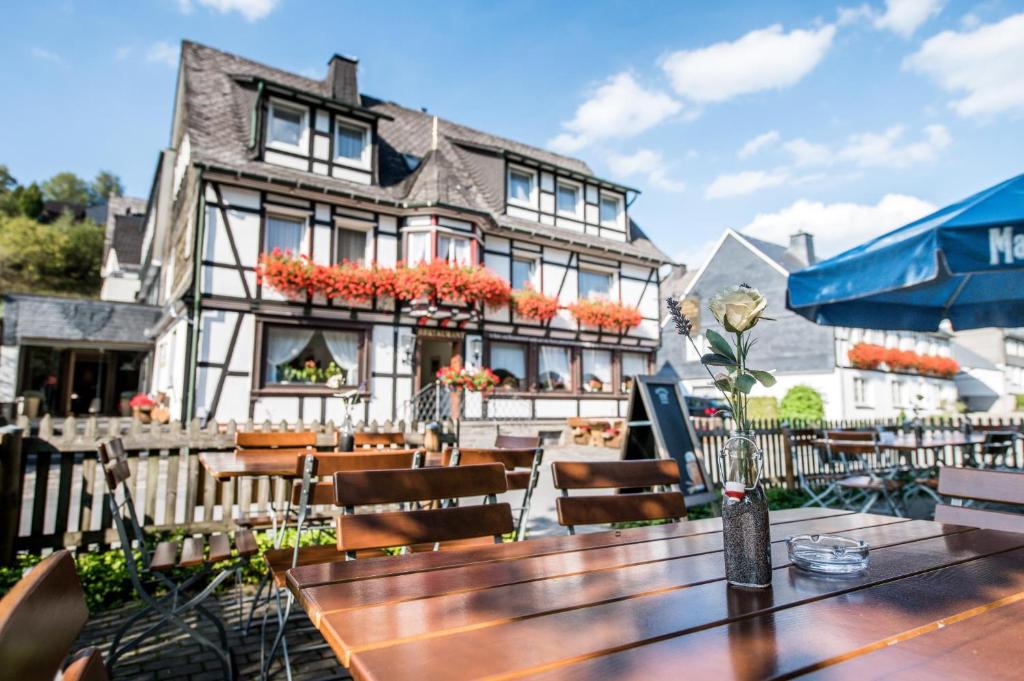 ein Restaurant mit Tischen und Stühlen vor einem Gebäude in der Unterkunft Hotel Hanses-Bräutigam in Schmallenberg