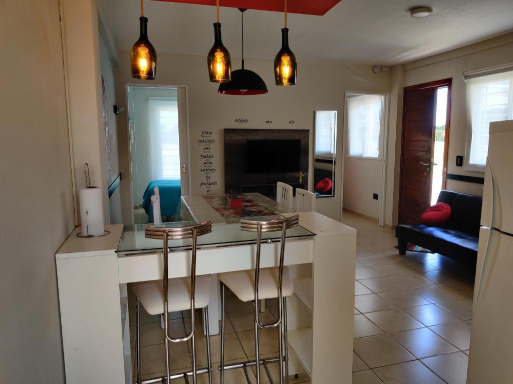 a kitchen with a white island with bar stools at Luz de faro in Mar del Plata