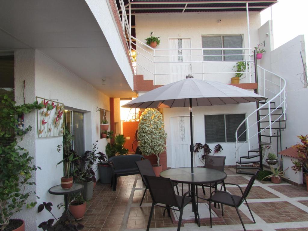 Villa Layla Santa Marta في سانتا مارتا: فناء في الهواء الطلق مع طاولة ومظلة